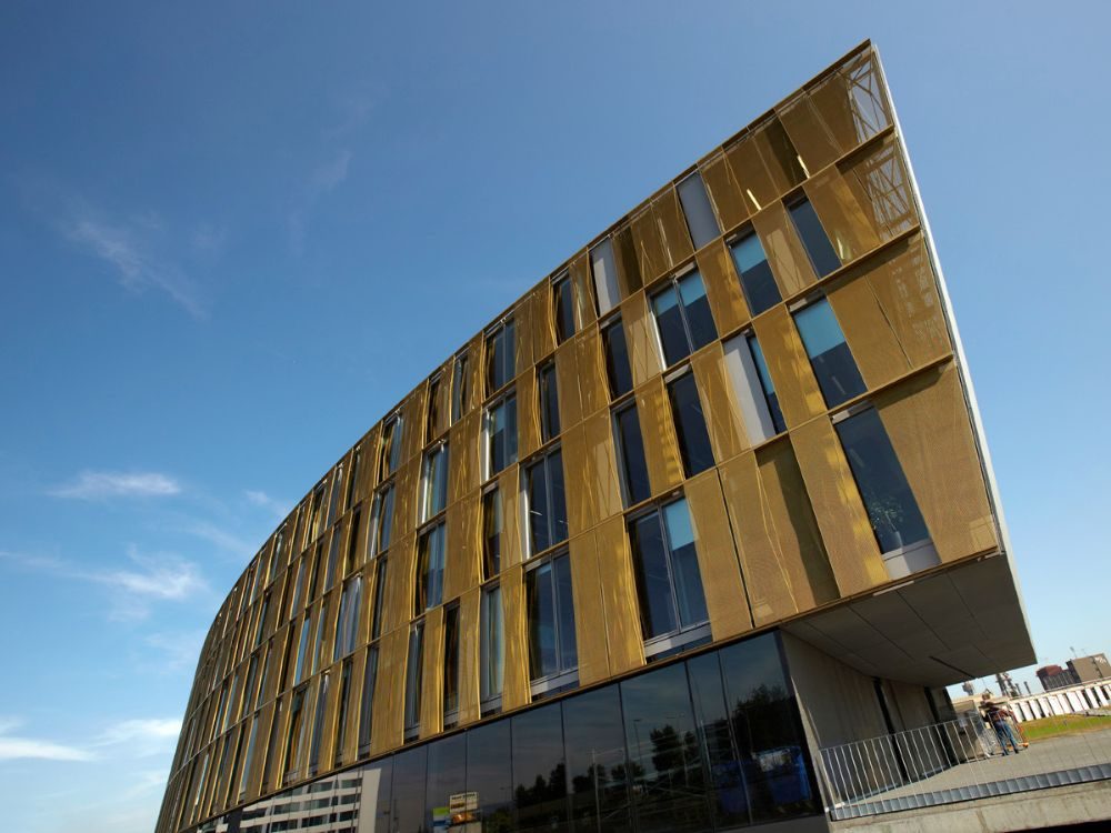Fassade der voestalpine AG Linz mit elektrisch steuerbaren, horizontal schwenkbaren Sonnenschutzlamellen aus geschosshohen Streckmetall-Paneelen